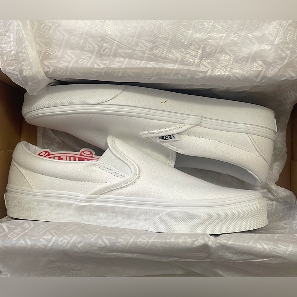 White canvas slip-on vans with tags